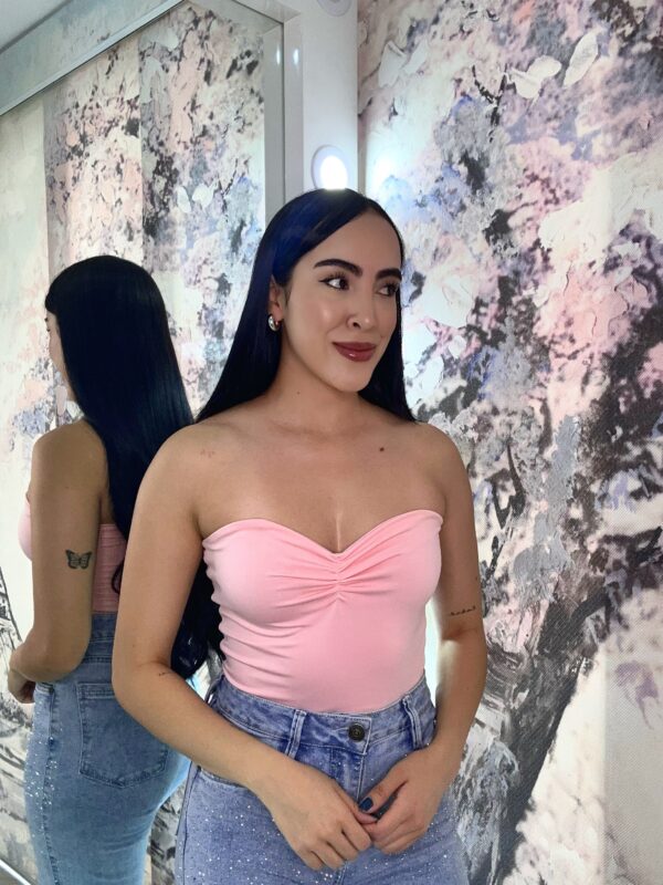 Modelo usando Body Shine Heart strapless rosado con escote corazón y fruncido central, combinado con jeans de tiro alto.
